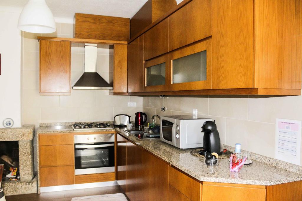 uma cozinha com armrios de madeira e uma bancada em Quinta Cho do Nabal em Belmonte
