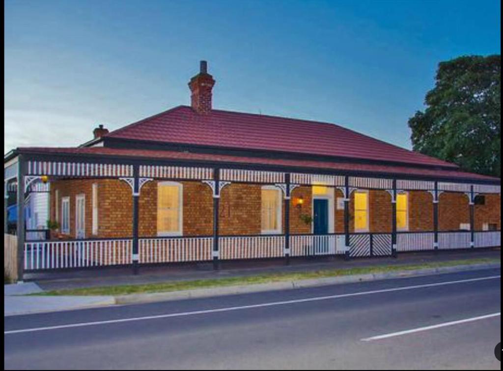 a large brick building with a red roof on a street at Blackwood House in Healesville