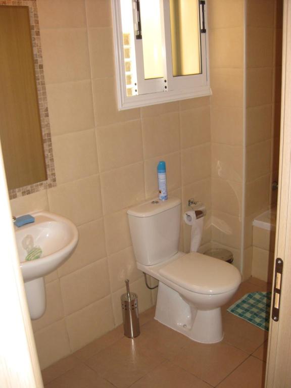 y baño con aseo y lavamanos. en Pyla Village Resort F110 (Apartment near Larnaca) en Pyla
