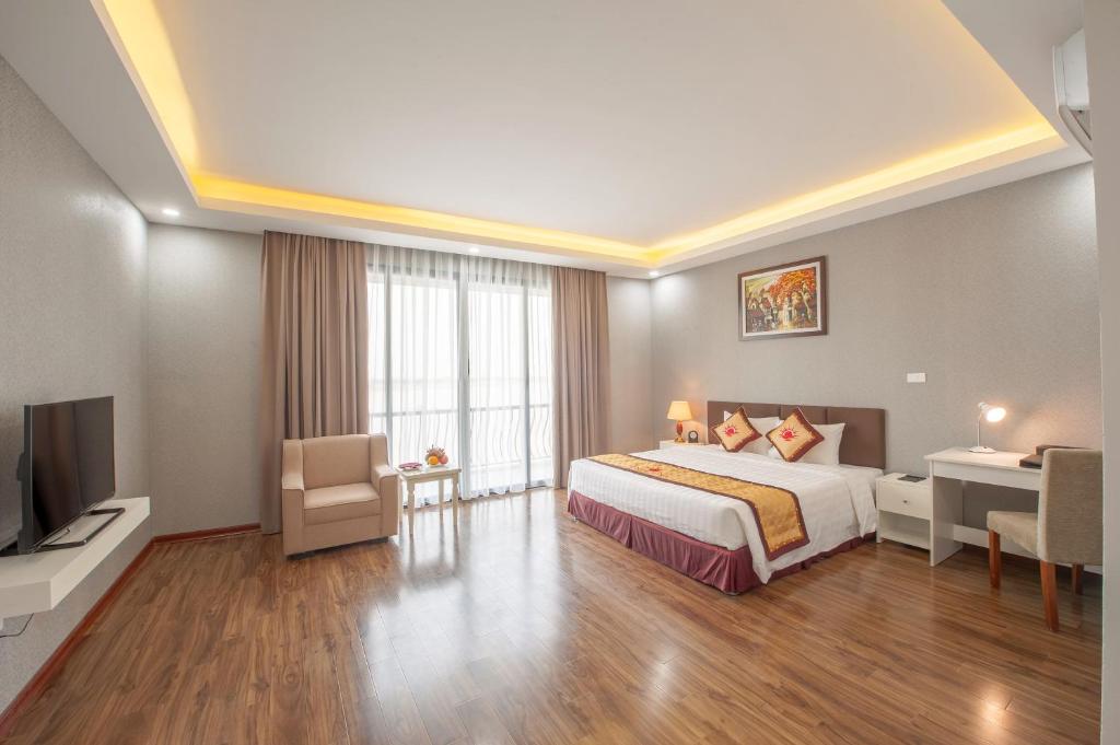 - une chambre avec un lit, un bureau et une télévision dans l'établissement Sunrise Hanoi Hotel, à Hanoï