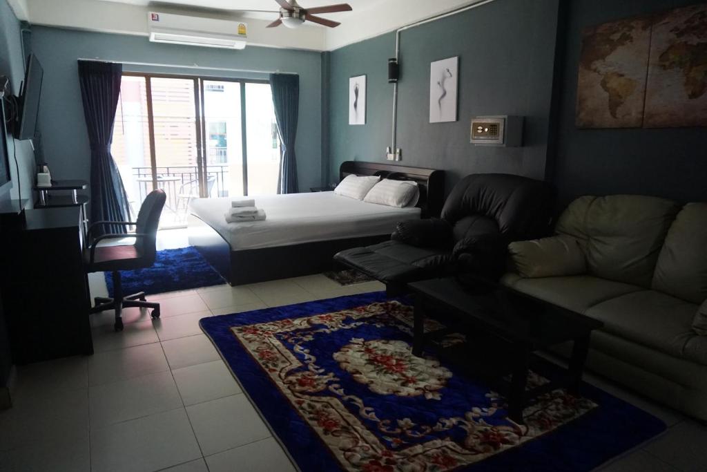 ein Wohnzimmer mit einem Bett und einem Sofa in der Unterkunft Nieuw Vlaanderen in Pattaya