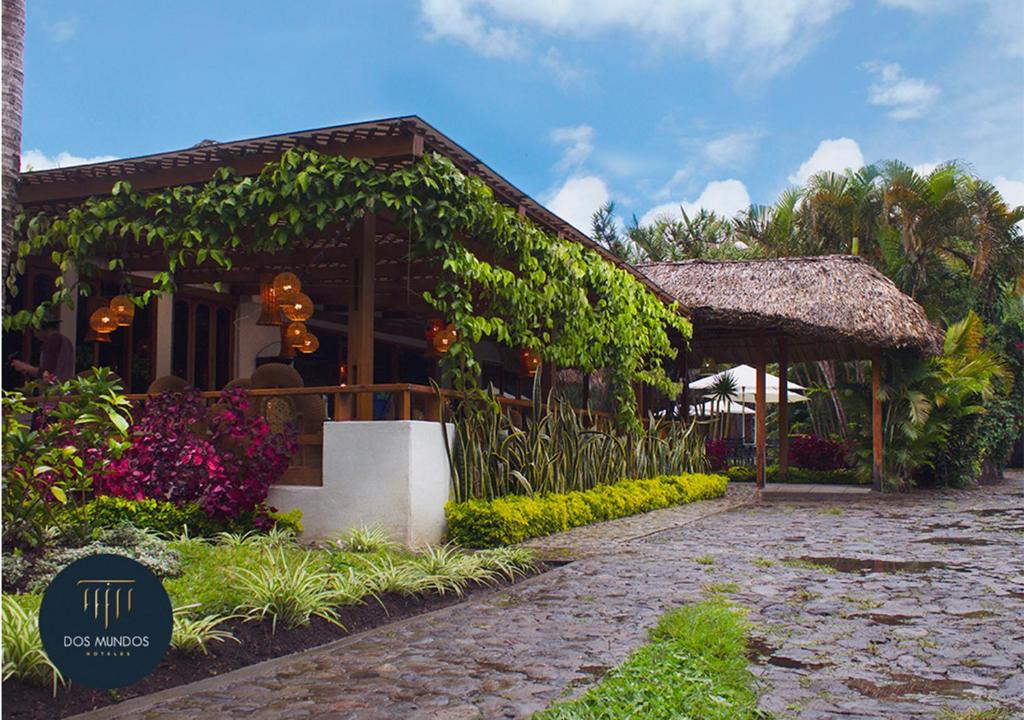 a resort with a building with plants and flowers at Hotel Dos Mundos Panajachel in Panajachel
