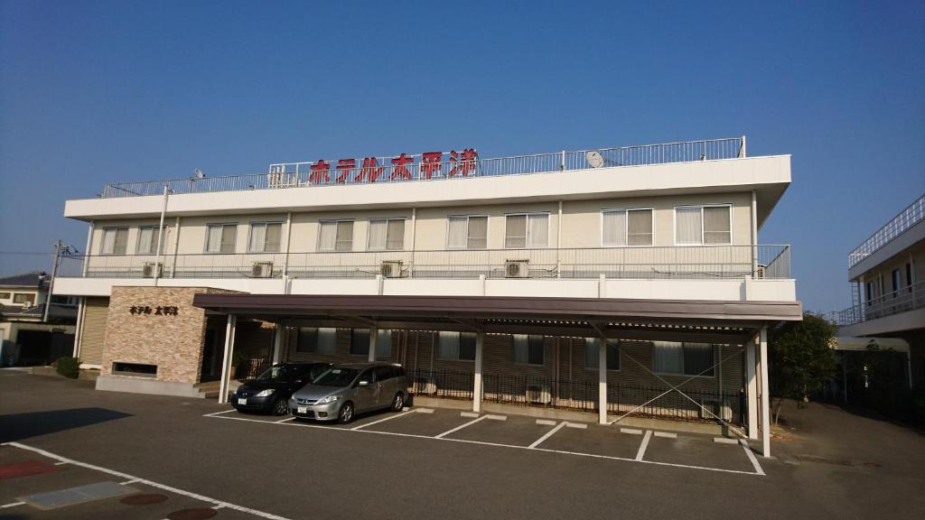 a building with a car parked in a parking lot at Hotel Taiheiyo in Matsushige