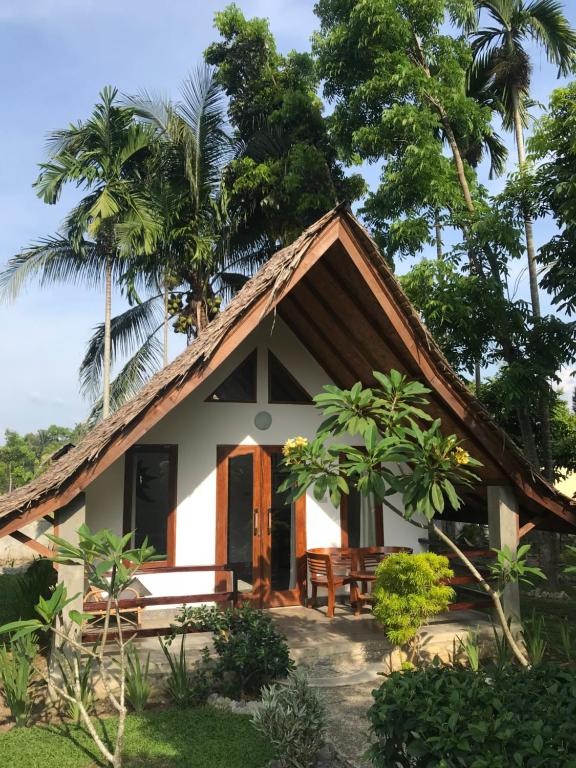 a small house with a thatched roof at Villa Paradise - Bukit Lawang in Bukit Lawang