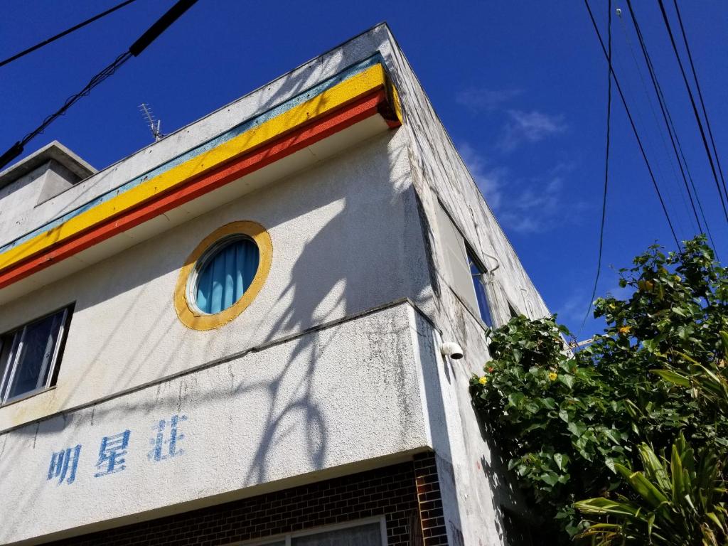 a building with a rainbow on the side of it at Minshuku Myojoso in Yoron