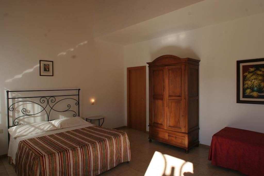 1 dormitorio con 1 cama y armario de madera en Masseria Casacapanna, en Chieuti