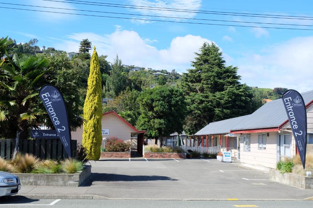 a parking lot with signs in front of a building at Castles Motel & Driftwood Motel in Nelson