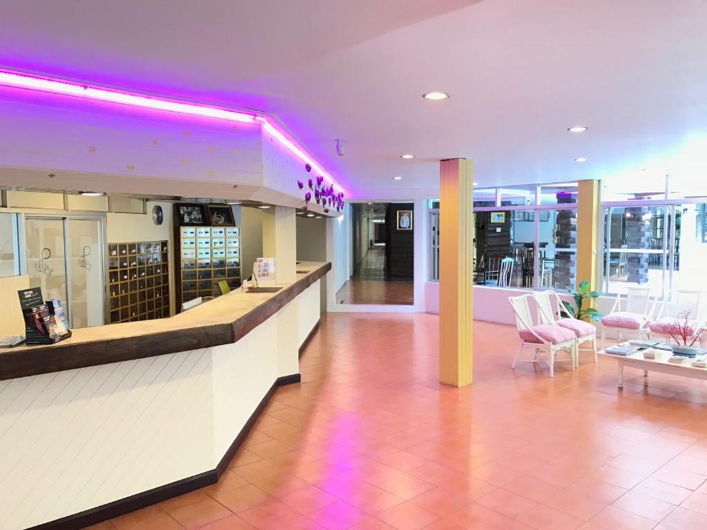 a lobby with a bar with purple lights on it at Pattaya At Nine in Pattaya Central