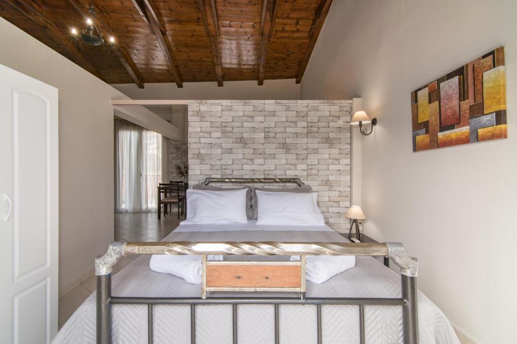a bedroom with a bed and a brick wall at Semeli Apartment in Zakynthos Town