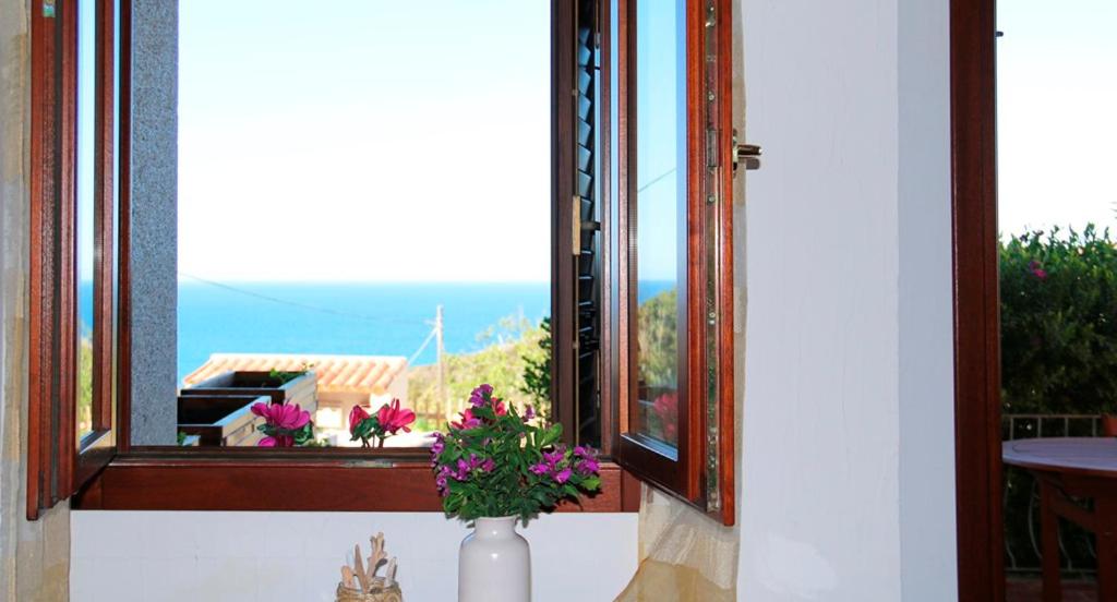 a vase with flowers sitting on a window sill at SARDINIA RE - Casa Cipro in Castelsardo