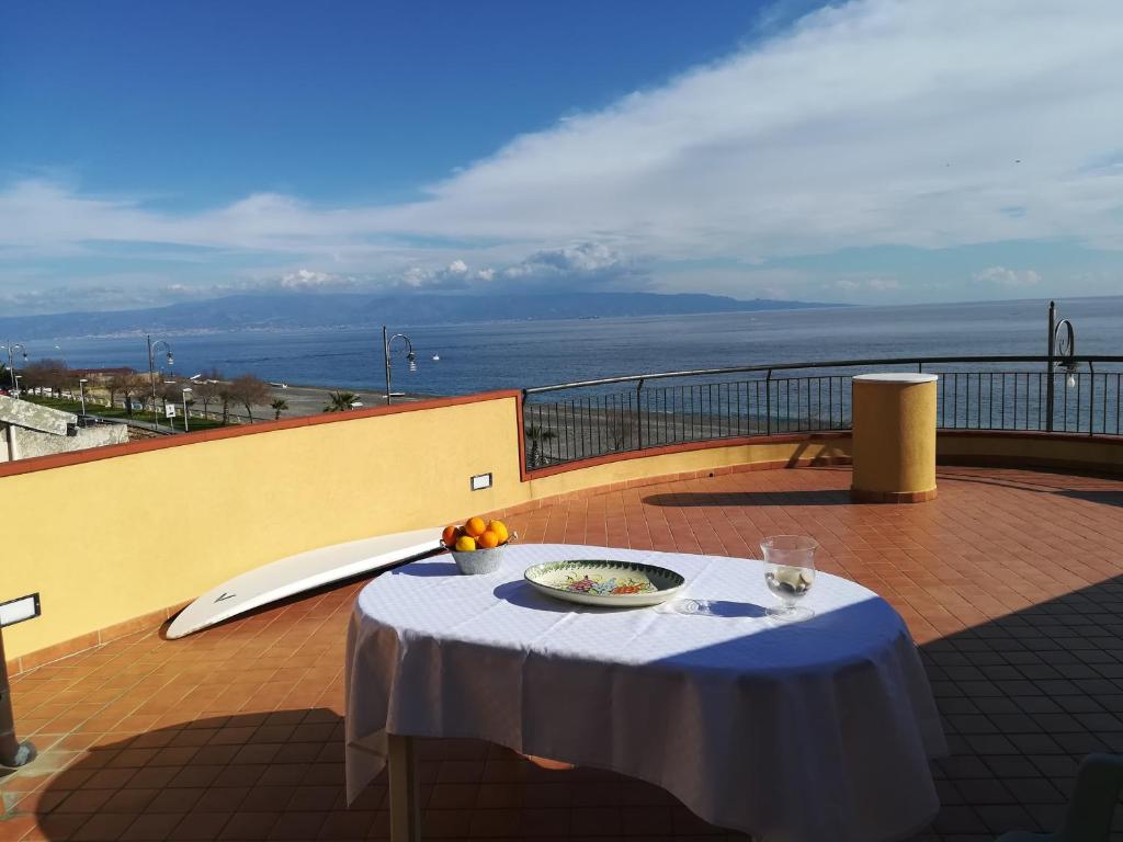 a table on a balcony with a view of the ocean at Casa Carmelo in Nizza di Sicilia