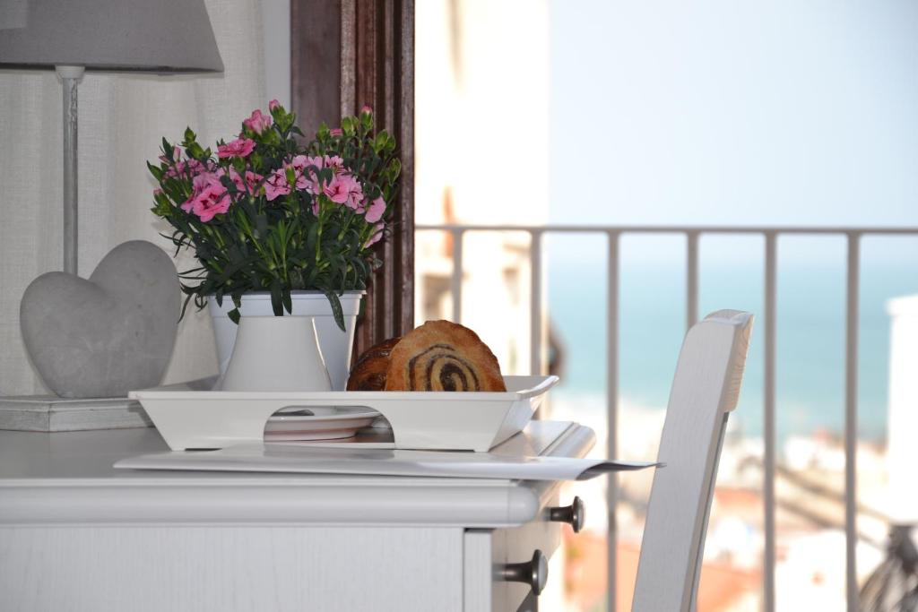 einen Tisch mit einer Blumenvase darüber in der Unterkunft Cuore di Vieste in Vieste