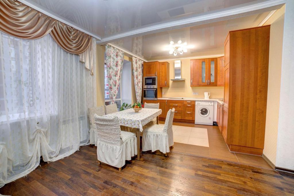 a kitchen with a table and chairs and a kitchen with a kitchen at Apartament on Sovetskaya lux in Tomsk
