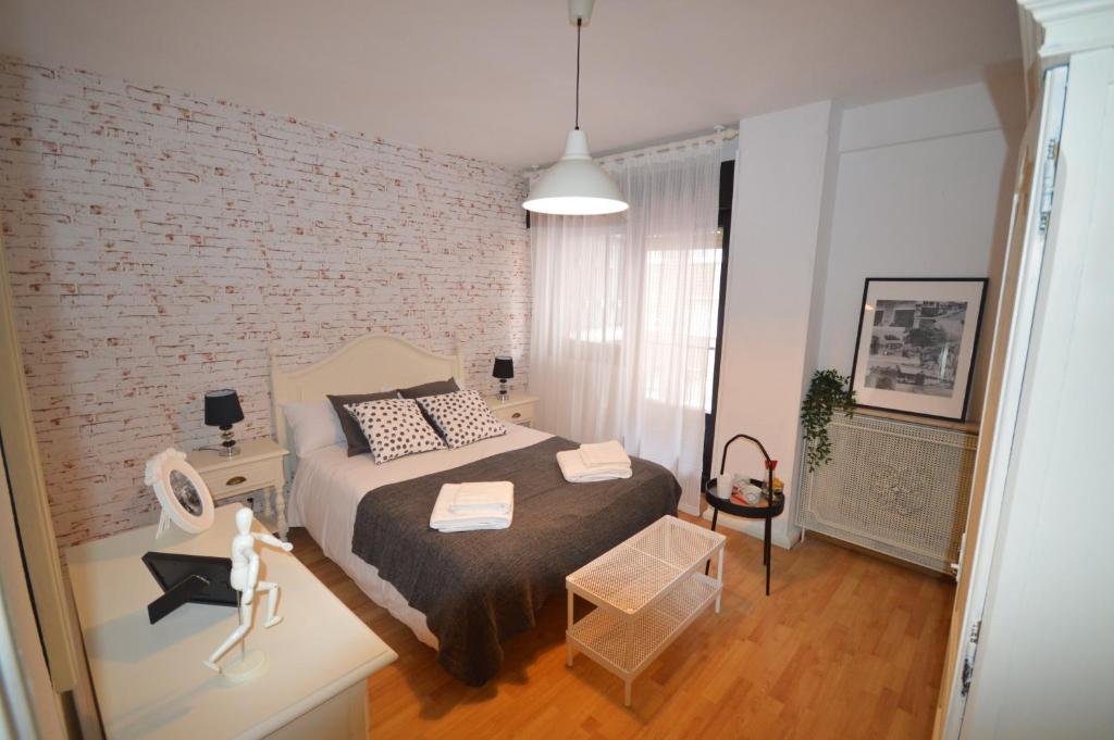 a bedroom with a bed and a brick wall at Apartamento Fleta in Zaragoza