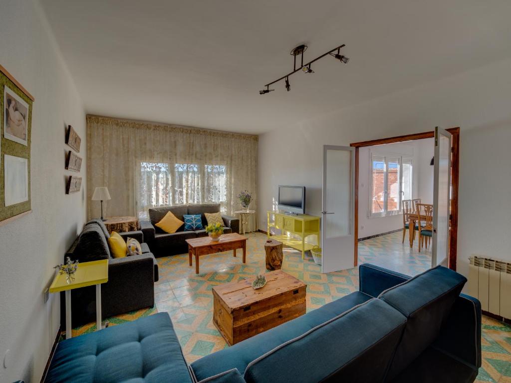 a living room with a blue couch and a table at Casa Arbós in Arbeca