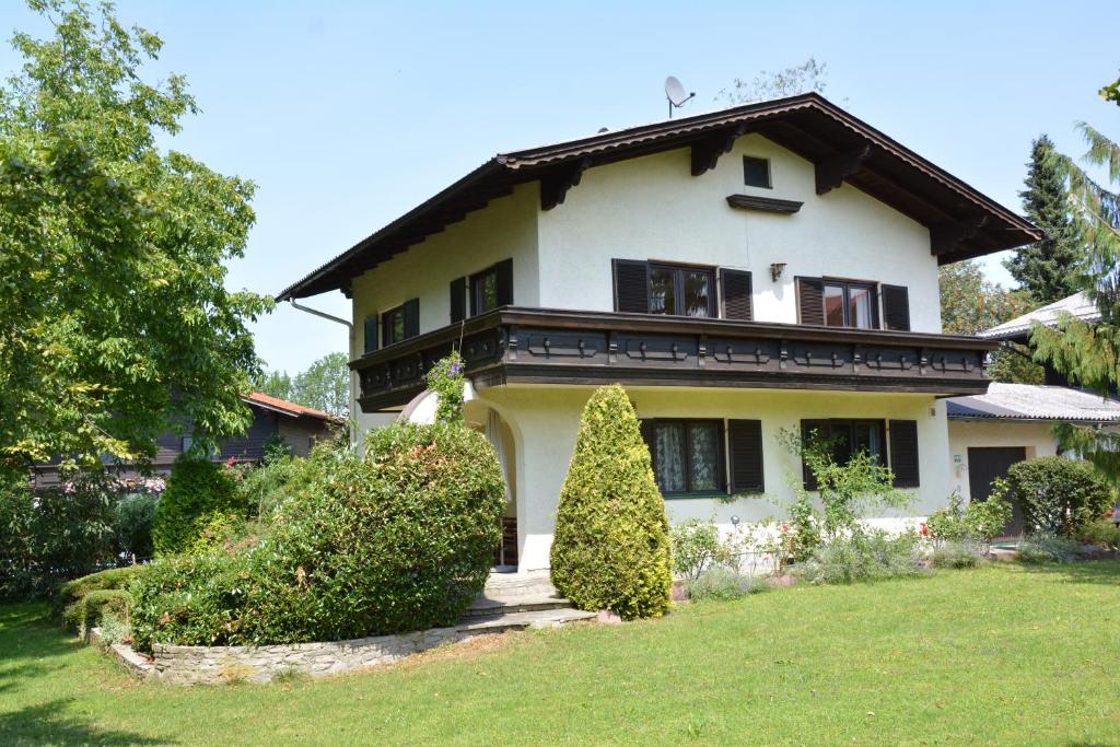 a large white house with bushes in the yard at Haus mit Garten in Eugendorf