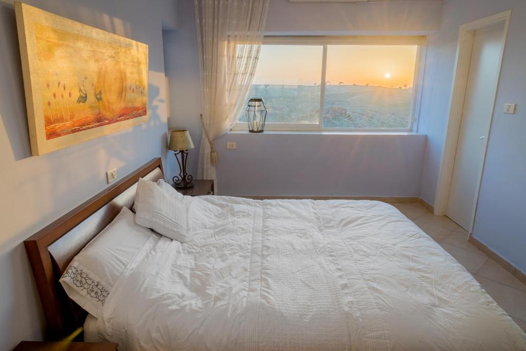 a white bed in a bedroom with a window at Sweet Home in Arad