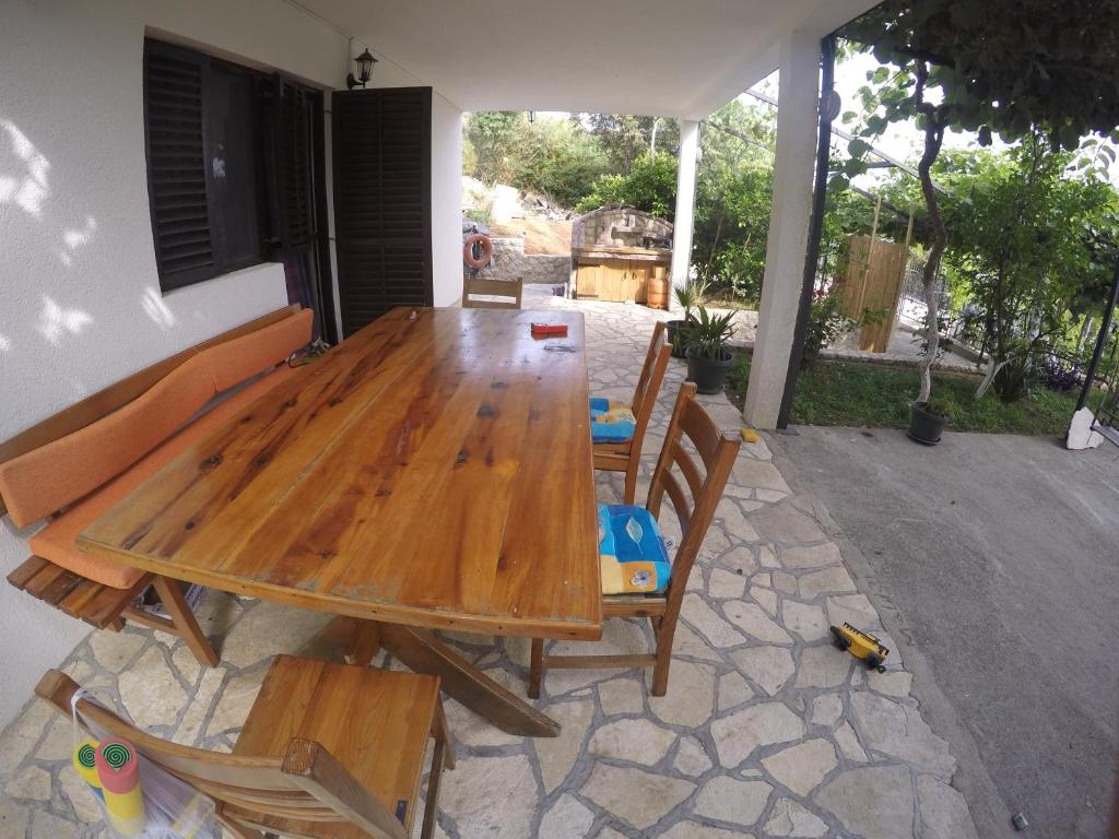 een houten tafel en stoelen op een patio bij Holiday Home Free your mind in Dobra Voda