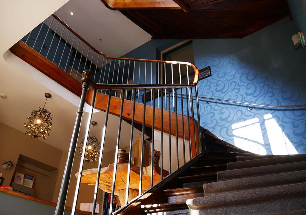 eine Wendeltreppe in einem Haus mit einem Kronleuchter in der Unterkunft Logis - Auberge de l'Abbaye in Thiron-Gardais