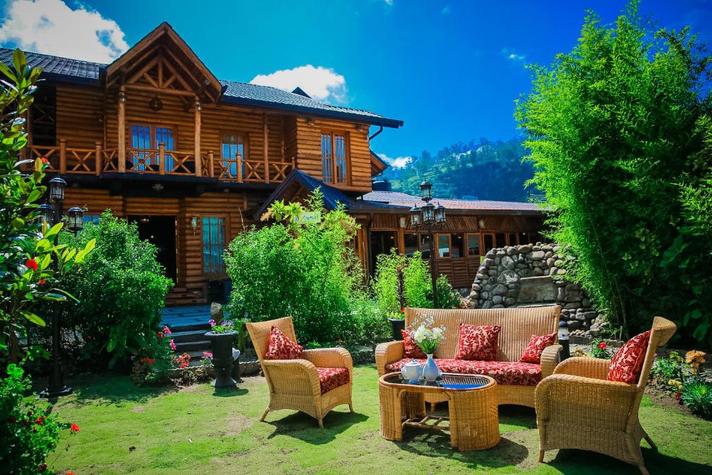a patio with chairs and a table in front of a house at Queenswood Cottage in Nuwara Eliya