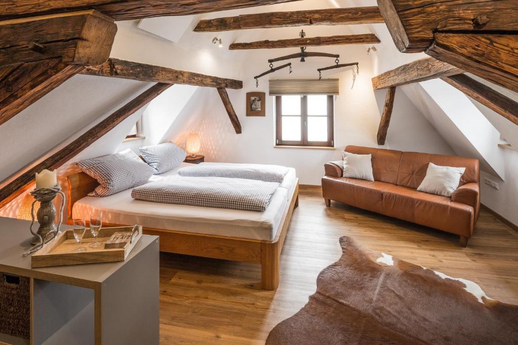 a attic bedroom with a bed and a couch at alte Ritterstube in Günzburg