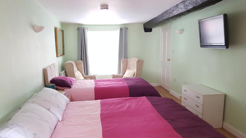 a bedroom with a bed and a window at Brookside Cottage in Okehampton