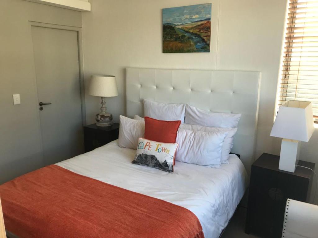 a bedroom with a bed with a pillow on it at 101Infinity in Bloubergstrand