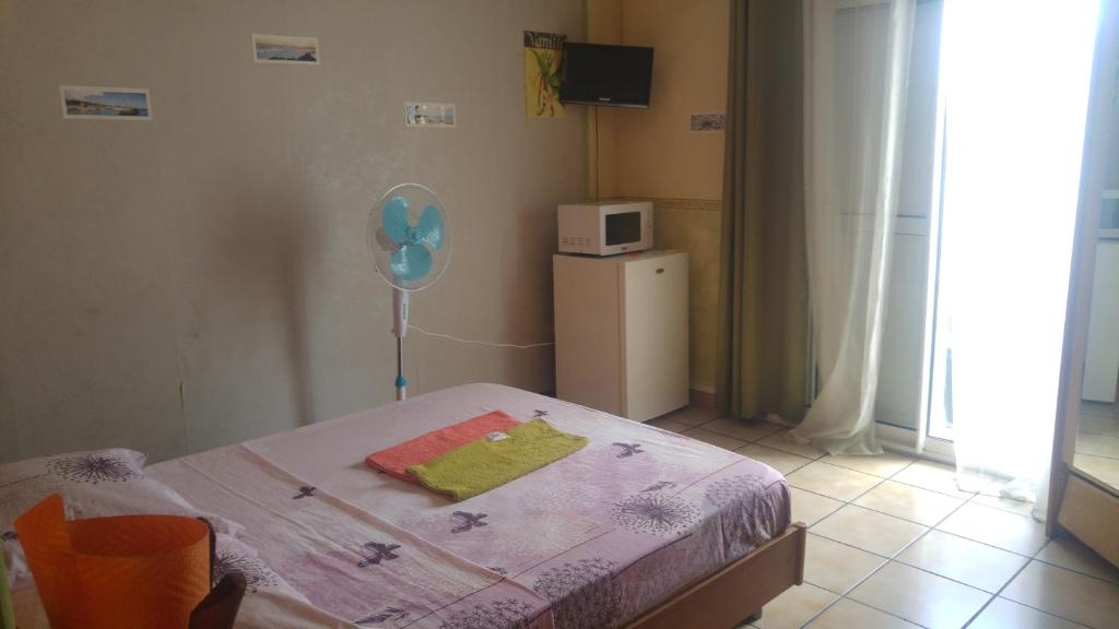 Schlafzimmer mit einem Bett mit einem Ballon und einer Mikrowelle in der Unterkunft Le Cap Vert in Sainte-Clotilde