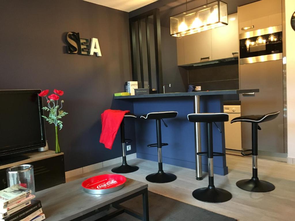 a kitchen with a blue counter and stools at Le Belouga in Pornichet