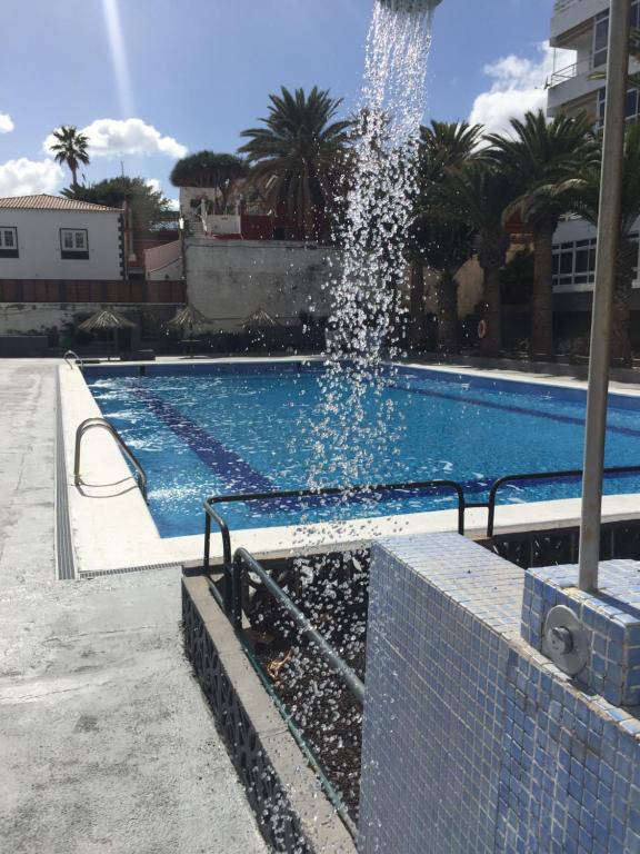 una fuente de agua en una piscina en Cozy Apartment, en Candelaria