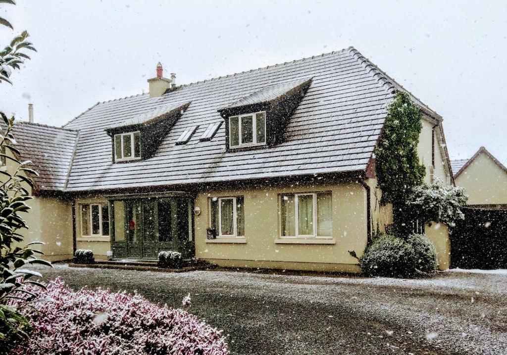 une maison avec un toit recouvert de neige dans l'établissement The Hollies, à Adare