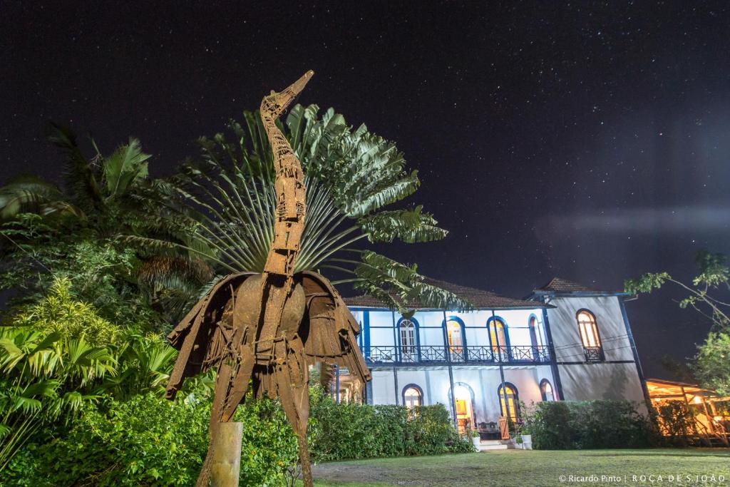 a statue of a palm tree in front of a building at Roça São João dos Angolares in Santa Cruz