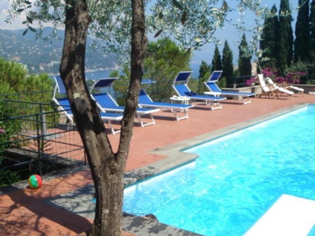 a group of blue lounge chairs next to a swimming pool at Cottage san Michele in Rapallo