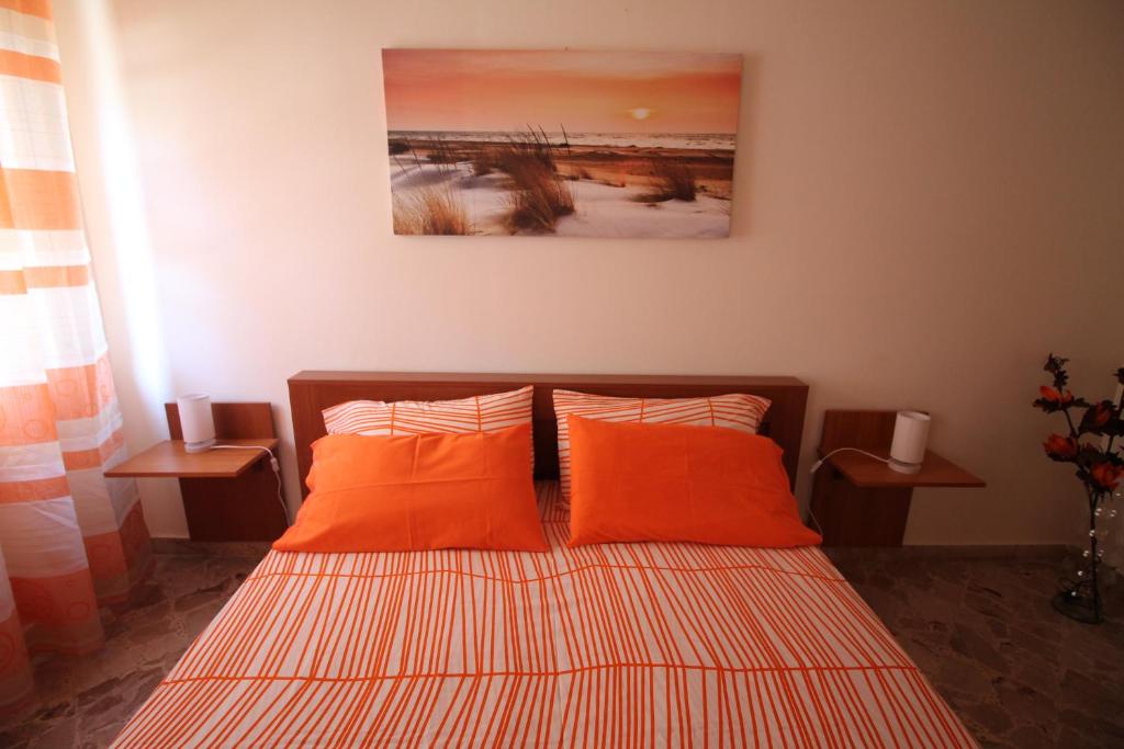 - un lit avec deux oreillers orange dans une chambre dans l'établissement Dea Beach, à Cefalù