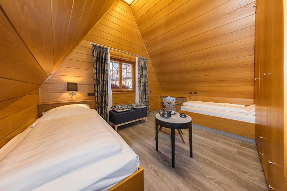 ein Schlafzimmer mit 2 Betten und einem Tisch in einem Zimmer in der Unterkunft Burghotel in Rothenburg ob der Tauber