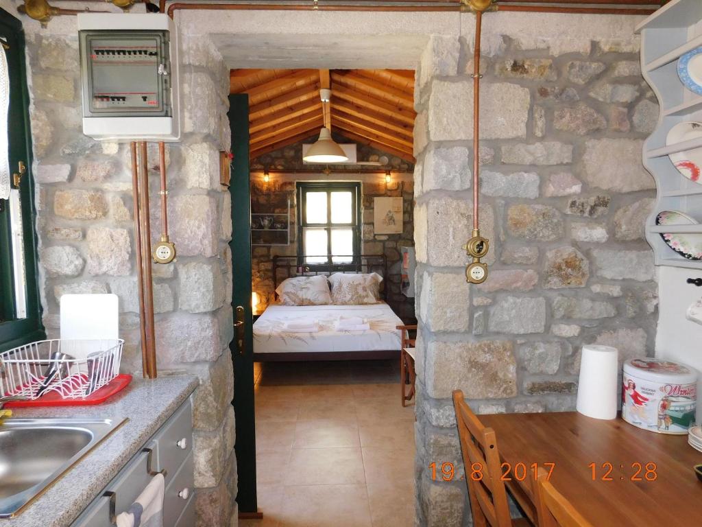 Pokój z sypialnią z łóżkiem i stołem w obiekcie Stone cottage for couple w mieście Thános