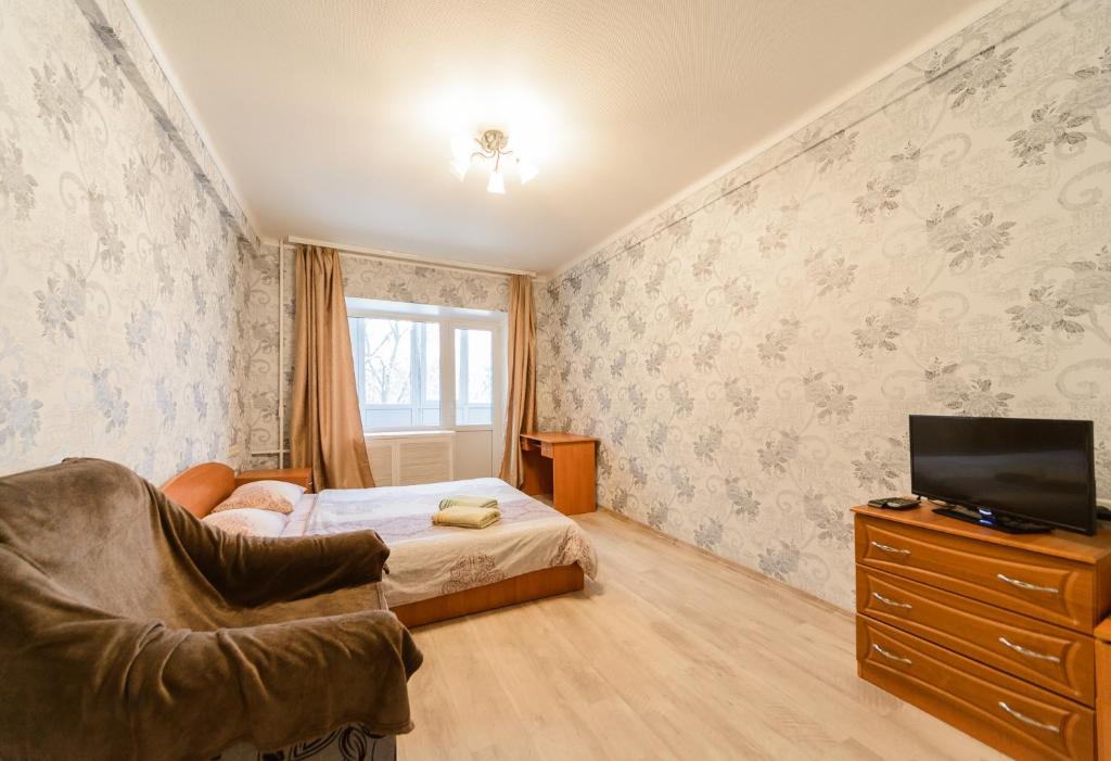 ein Schlafzimmer mit einem Bett, einem TV und einem Sofa in der Unterkunft Квартира по улице Цитадельная, 9 in Kiew