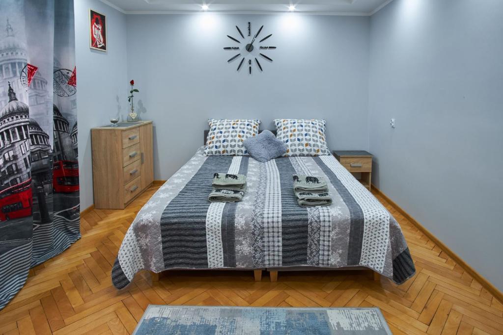 1 dormitorio con 1 cama con reloj en la pared en Apartamenty Lux Relax, en Białystok