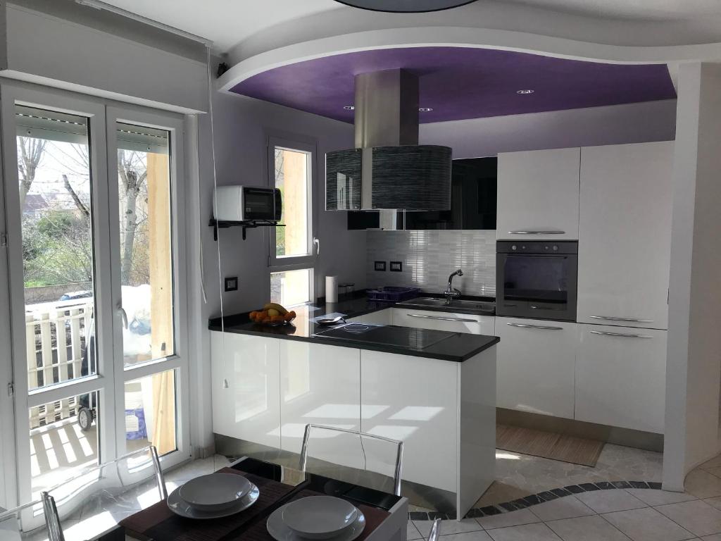 a kitchen with white cabinets and a purple ceiling at Dolce Sogno in Alghero