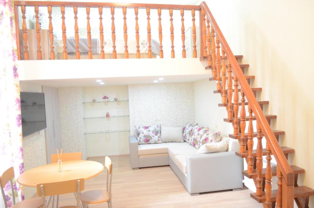 sala de estar con sofá blanco y escalera en Sololaki Hill en Tiflis
