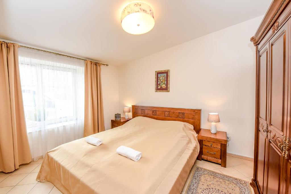 a bedroom with a bed with two towels on it at Kubu Apartment in Klaipėda