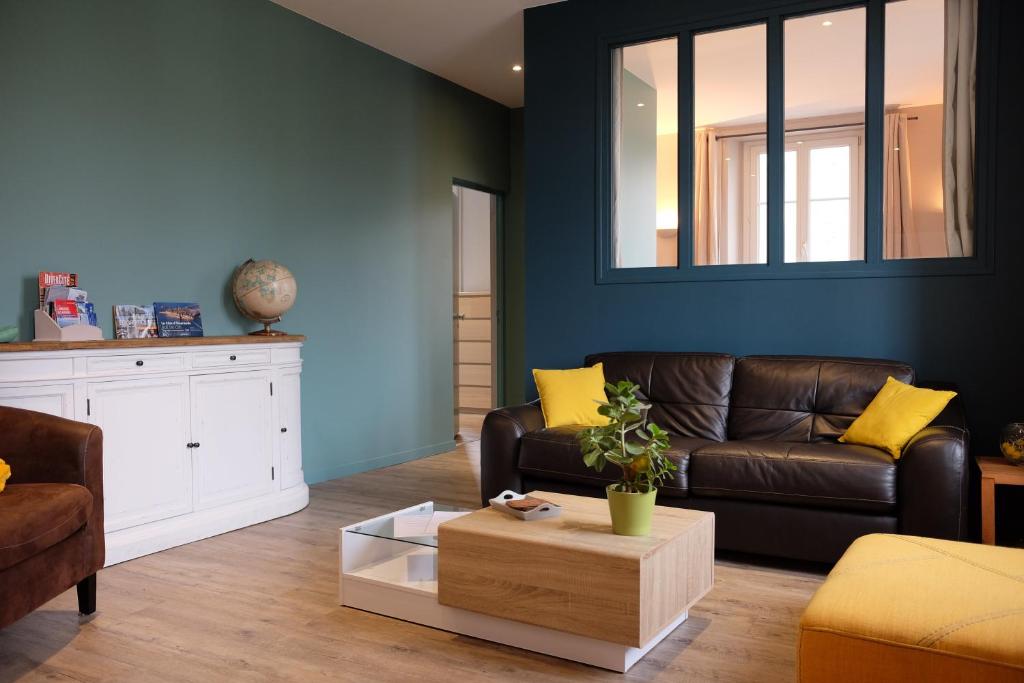 a living room with a brown couch and yellow pillows at Appartement Saint Malo-Rocabey in Saint Malo