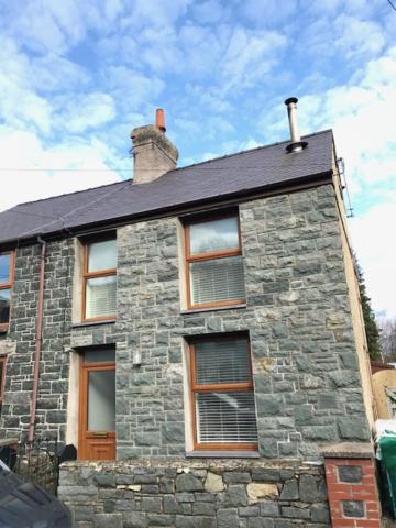 a stone house with windows and a roof at Snowdonia End Terrace in Caernarfon