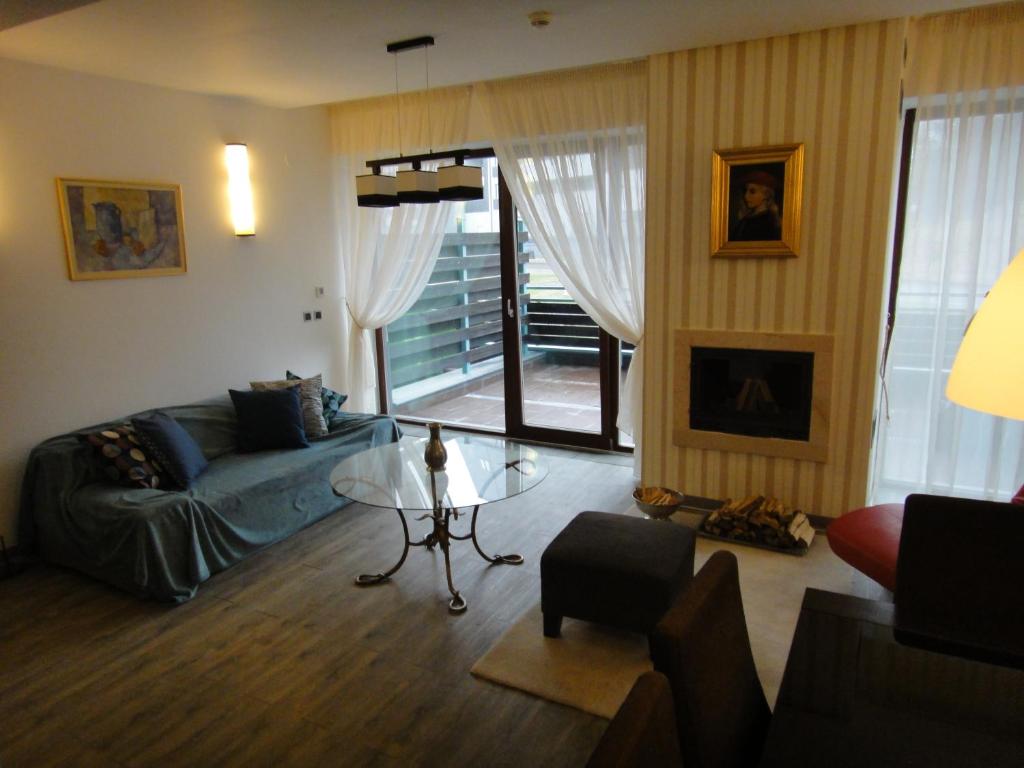 uma sala de estar com um sofá e uma mesa de vidro em Chambres Mountain em Poiana Brasov