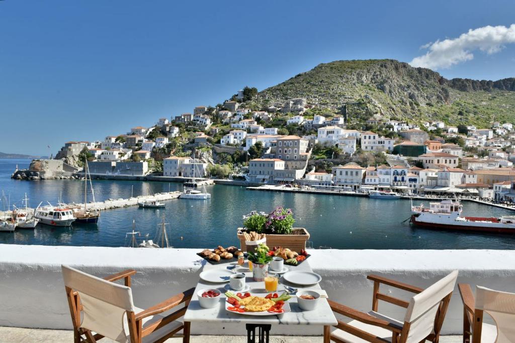 una mesa con comida y vistas al puerto en Douskos Port House, en Hydra