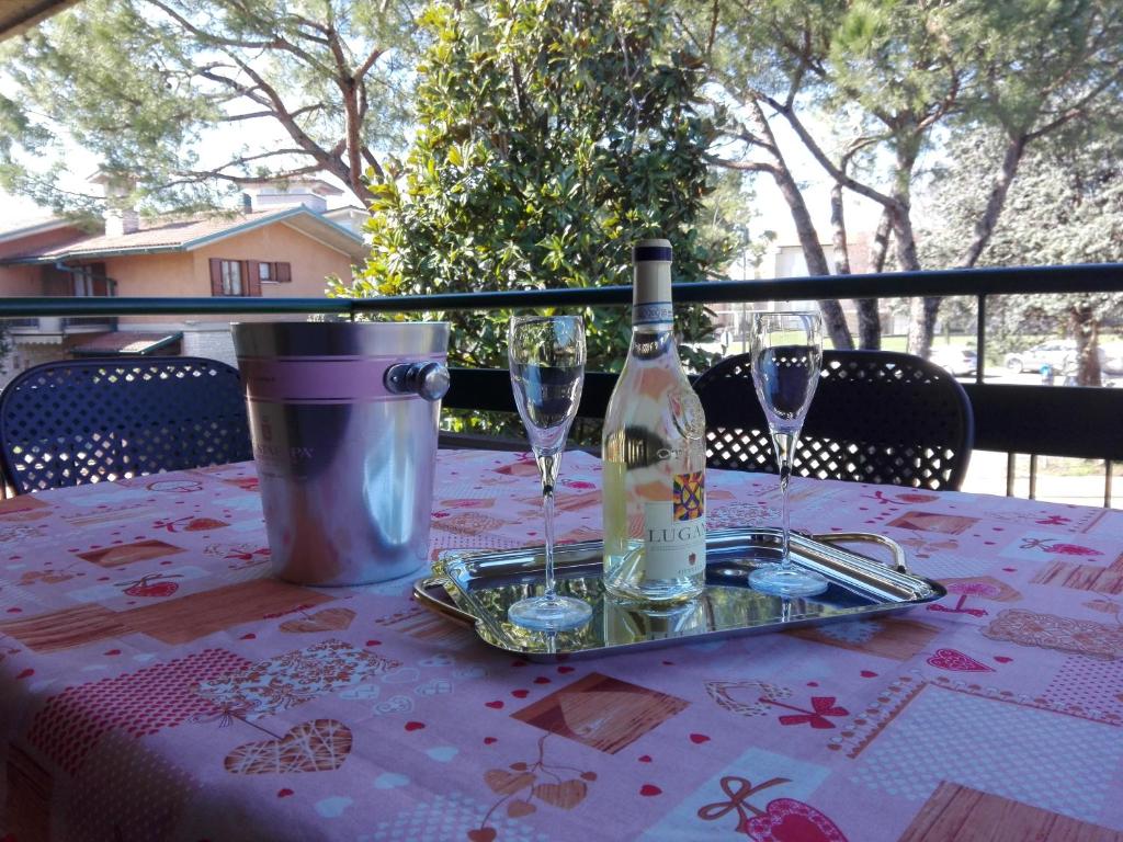 una botella de vino sentada en una mesa con copas en Casa Vacanza Clavel, en Sirmione