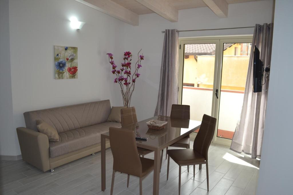 sala de estar con sofá, mesa y sillas en Planet apartments 2, en Montalbano Ionico