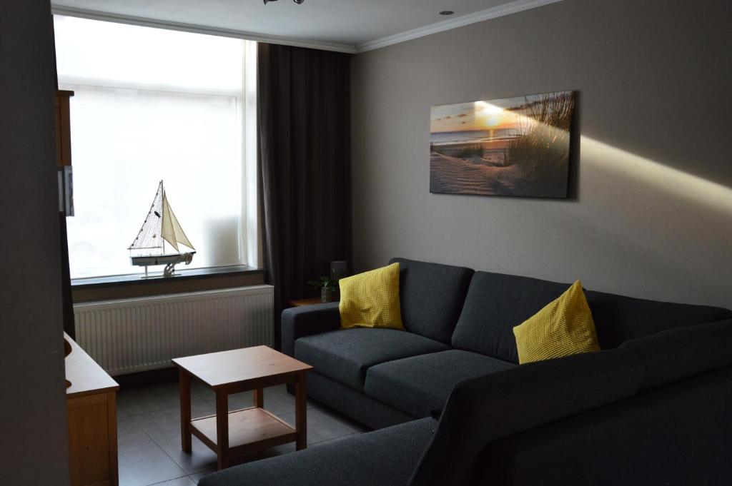 una sala de estar con sofá y un velero en la ventana en Vakantiehuis Jeanne Panne, en Nieuwpoort