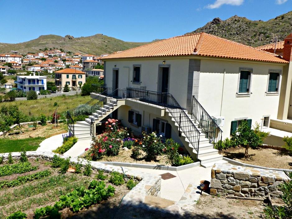 a house with stairs and flowers in a yard at Ktima Pyroessa Blue Suite in Thános