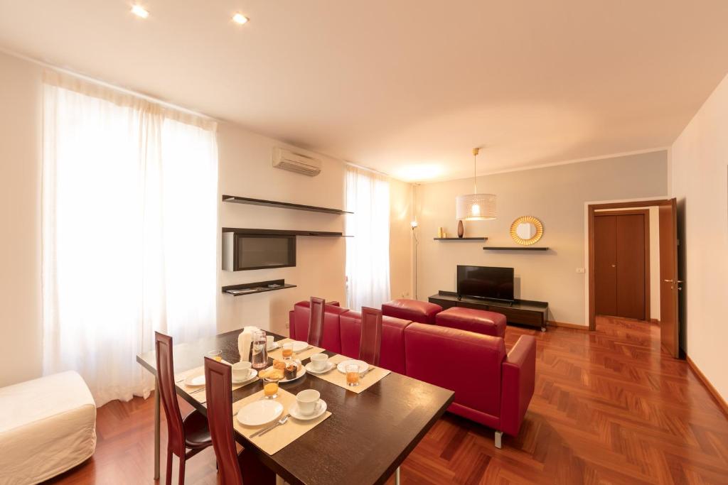 ein Wohnzimmer mit einem Esstisch und Stühlen in der Unterkunft Heart Milan Apartments Corso Como in Mailand
